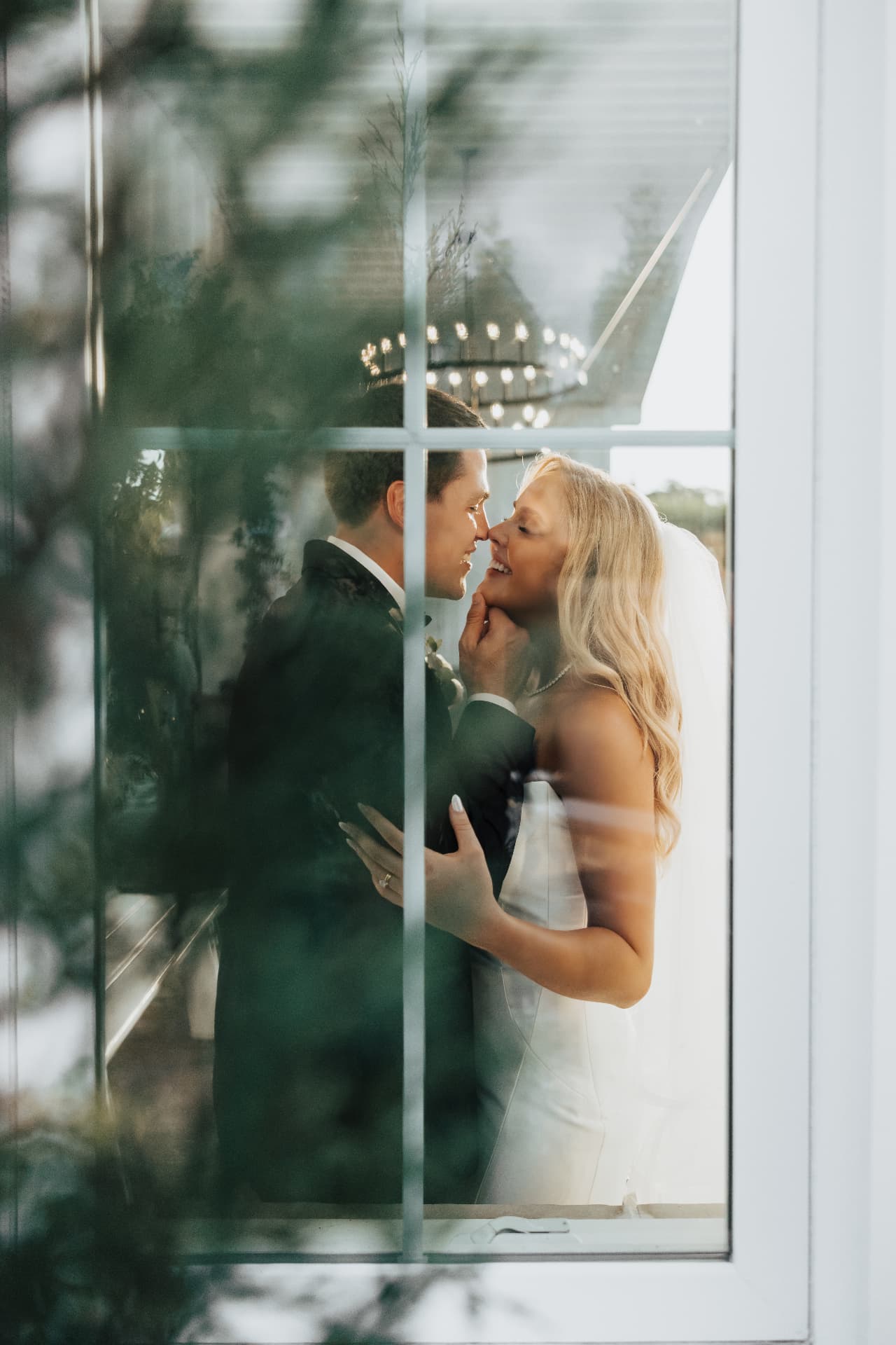 Couple embracing seen through a paned window with reflections