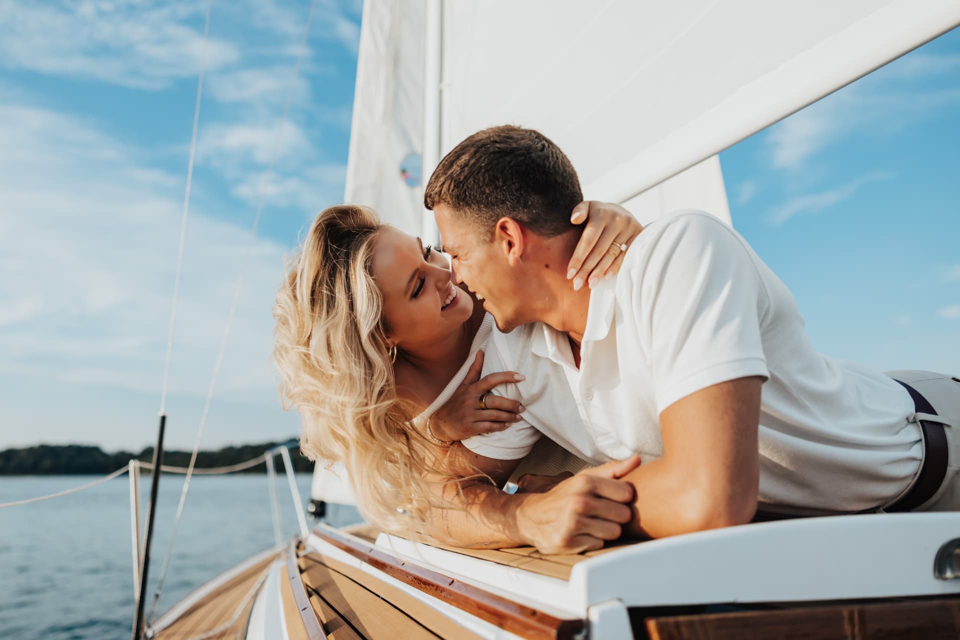 Couple laughing together lying on the deck of a sailboat