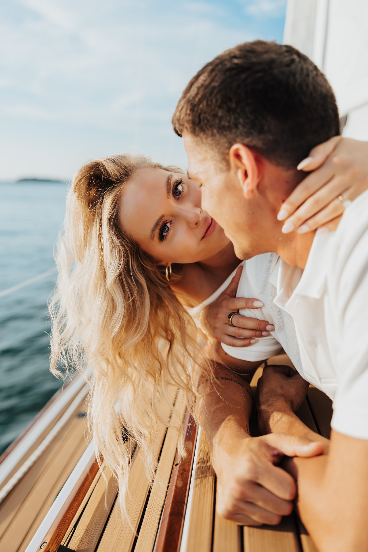 Close portrait of the couple resting on a teak sailboat deck
