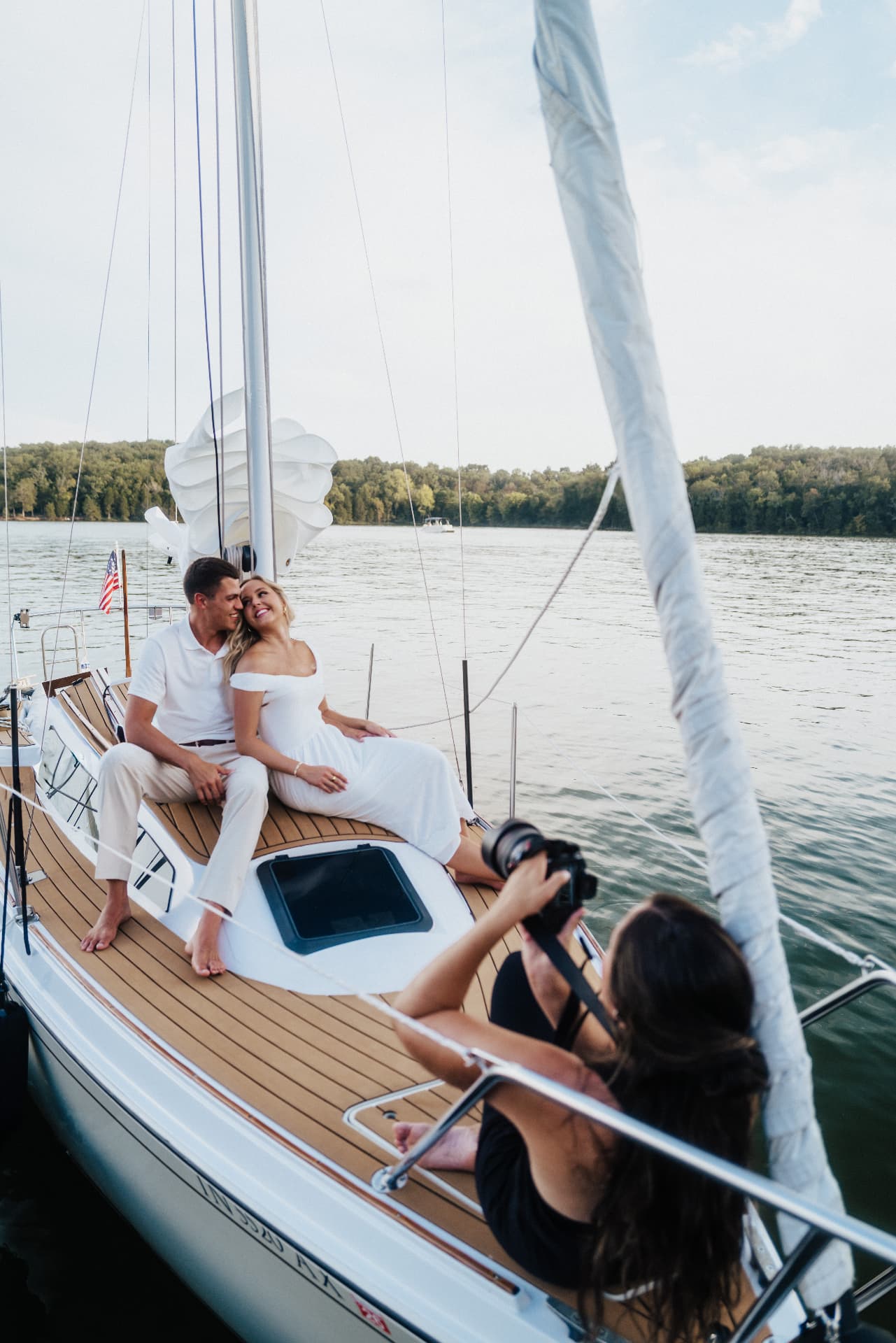 Photographer shooting the couple seated on a sailboat deck